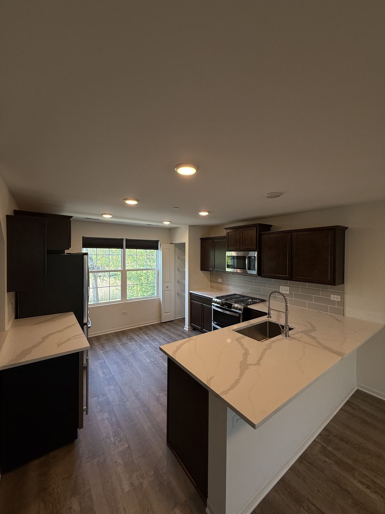 Quartz countertop and backsplash with vinyl plank flooring in a kitchen remodel
